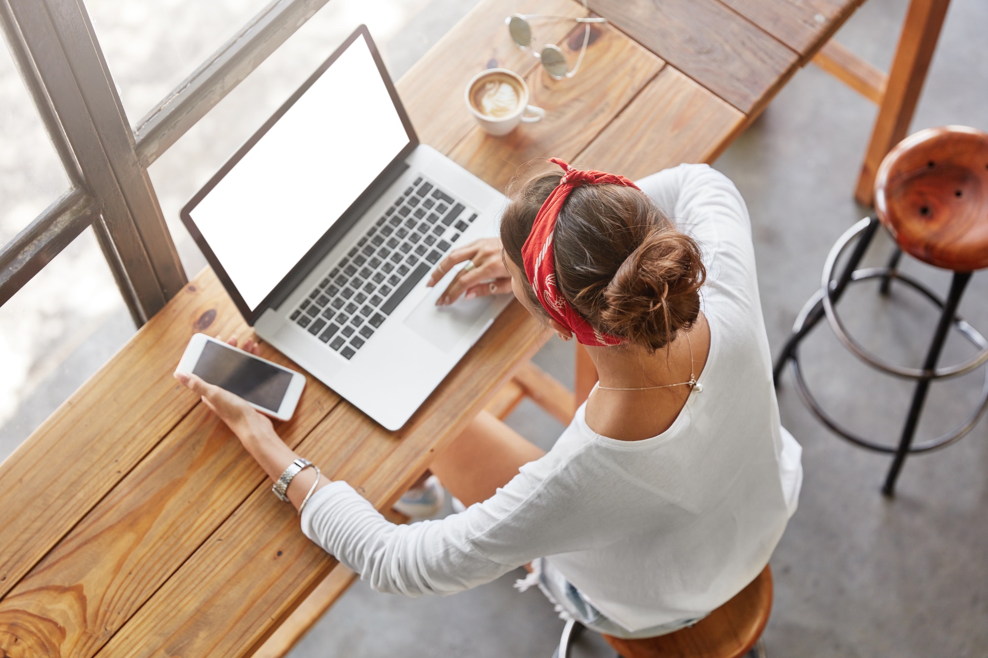 Top view of fashionable femle student learns online on laptop computer, prepares for classes or exam